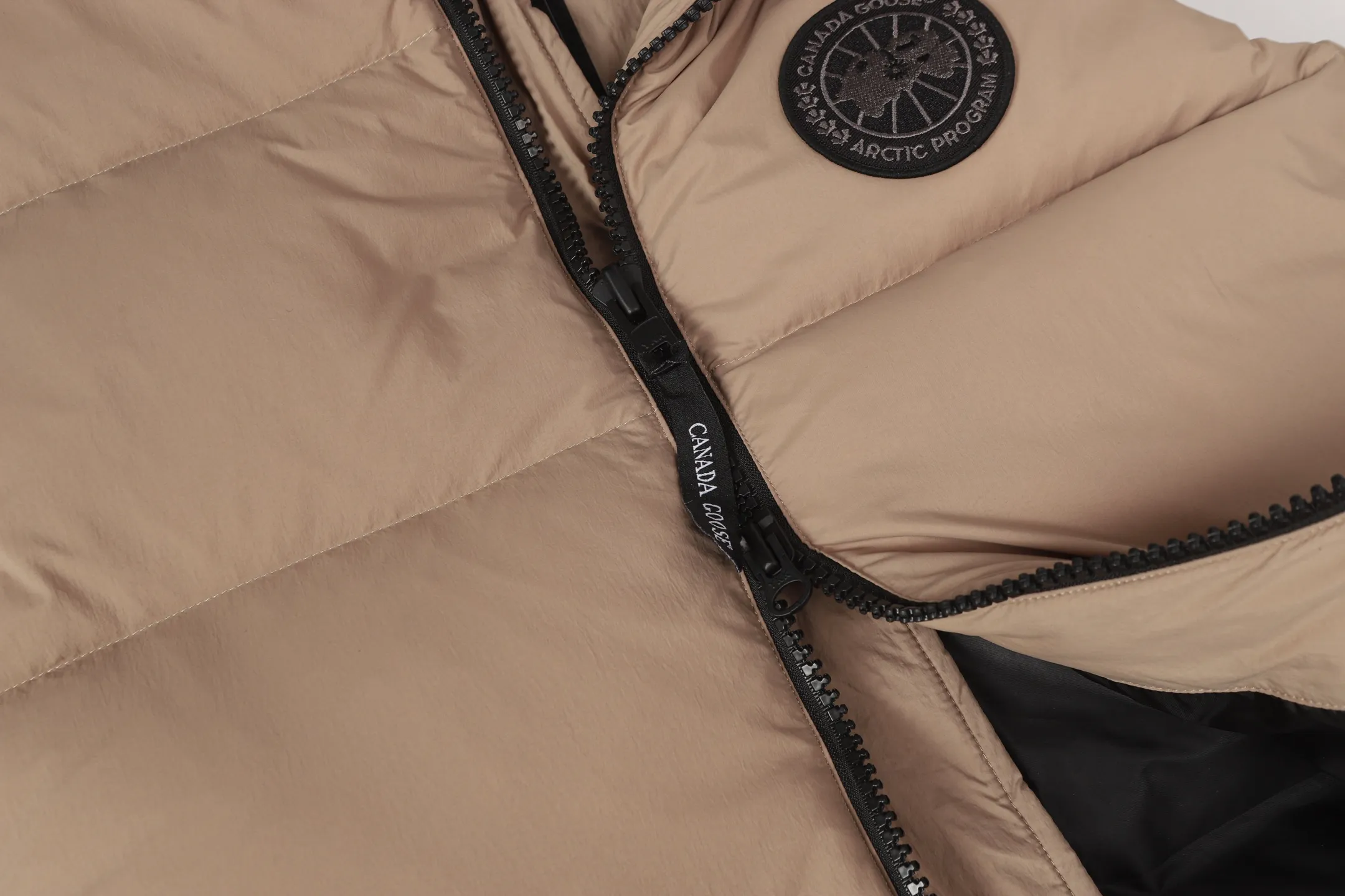 P560 Canada gooes Lawrence down vest (high version) The Lawrence down vest features a durable shell and quilted body, making it a must-have item for all seasons. The fabric has a durable soft touch. Longer hem at back for added protection. Reflective double-stripe grip tape at back. The Lawrence features an engineered down-filled collar to block strong winds, a two-way front zip and a longer rear hem.  Color: black with red label, black with black label, desert color, ocean blue Size: XS-2XL